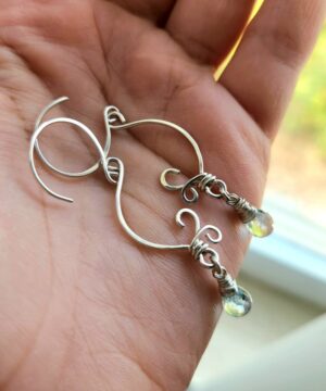 Hands holding beautiful aquamarine earrings handmade in sterling silver