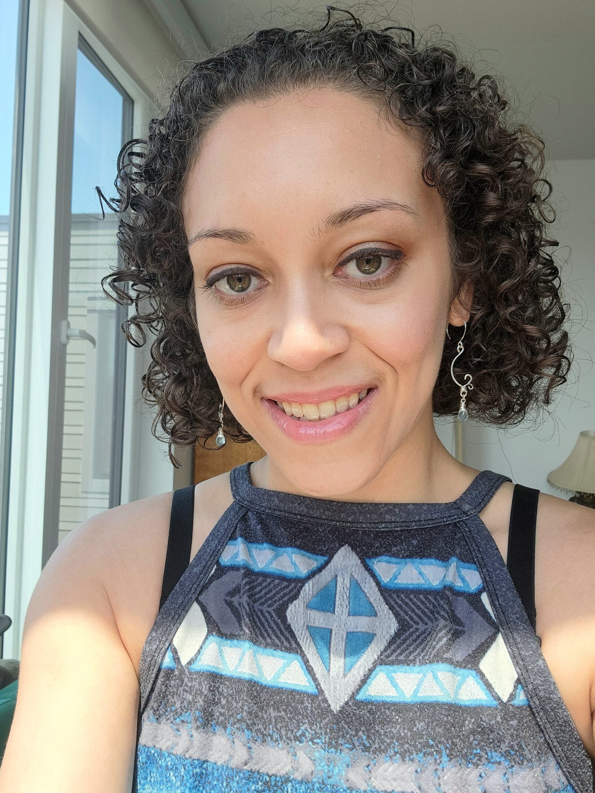 Christina Krasow, jewelry designer and jeweler for Woven Earth Jewelry, wearing aquamarine wire wrapped earrings