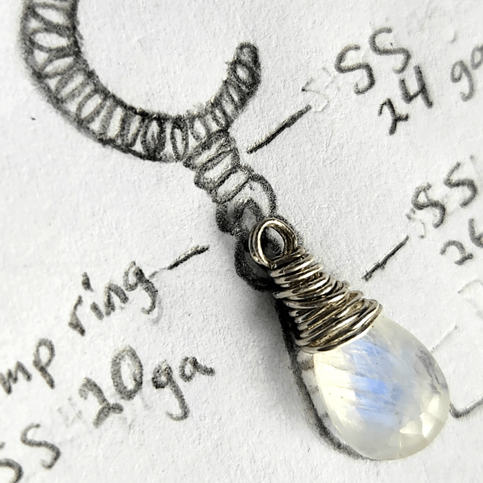 Glowing Within wire-wrapped celestial silver jewelry design with natural rainbow moonstone gemstone on top