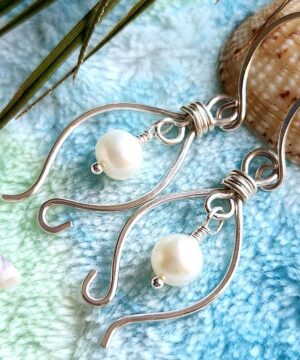Handmade sterling silver freshwater pearl earrings on blue blanket