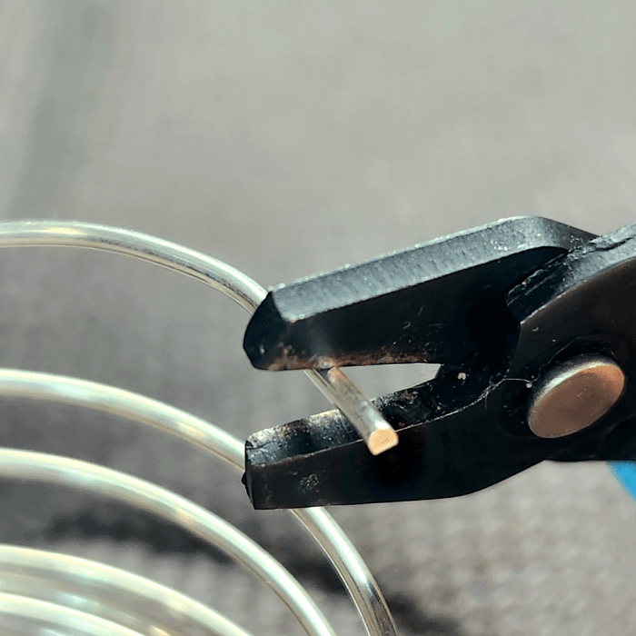 Using flush cutters to cut sterling silver wire to make handmade jewelry inspired by the sea