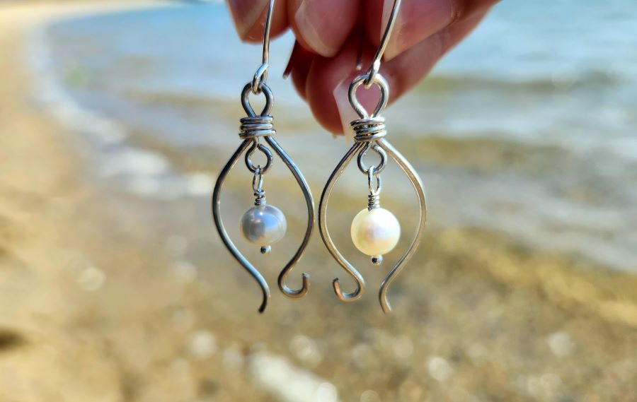 Sterling silver freshwater pearl earrings inspired by the coast with beach water in background
