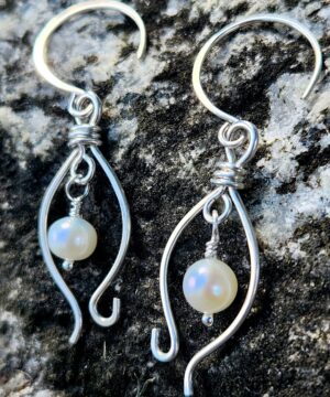 Sterling silver pearl jewelry closeup on rock