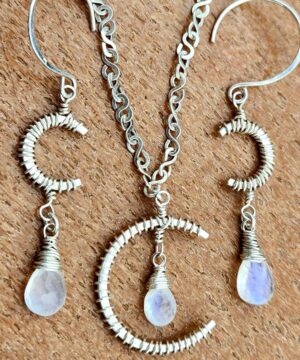 Sterling silver crescent moon jewelry set on bench