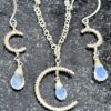 Sterling silver rainbow moonstone jewelry set on rock