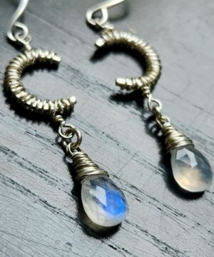 Sterling silver wire-wrapped moonstone earrings on table