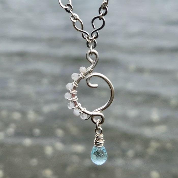 Handmade rainbow moonstone and aquamarine jewelry set in front of water