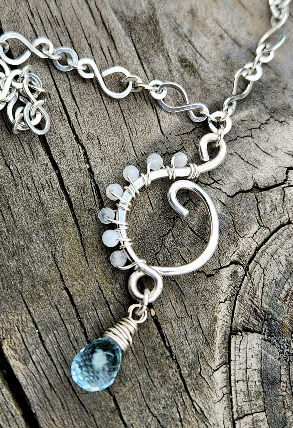 Handmade rainbow moonstone aquamarine pendant on wooden bench