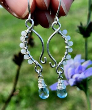 Handmade sterling silver aquamarine earrings in front of flowers