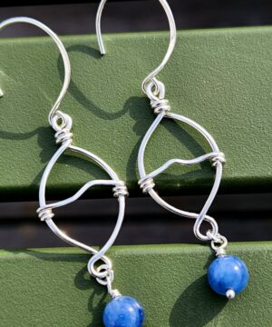 Handmade wire-wrapped kyanite earrings on green bench