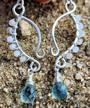 Handmade wire-wrapped moonstone jewelry in sand