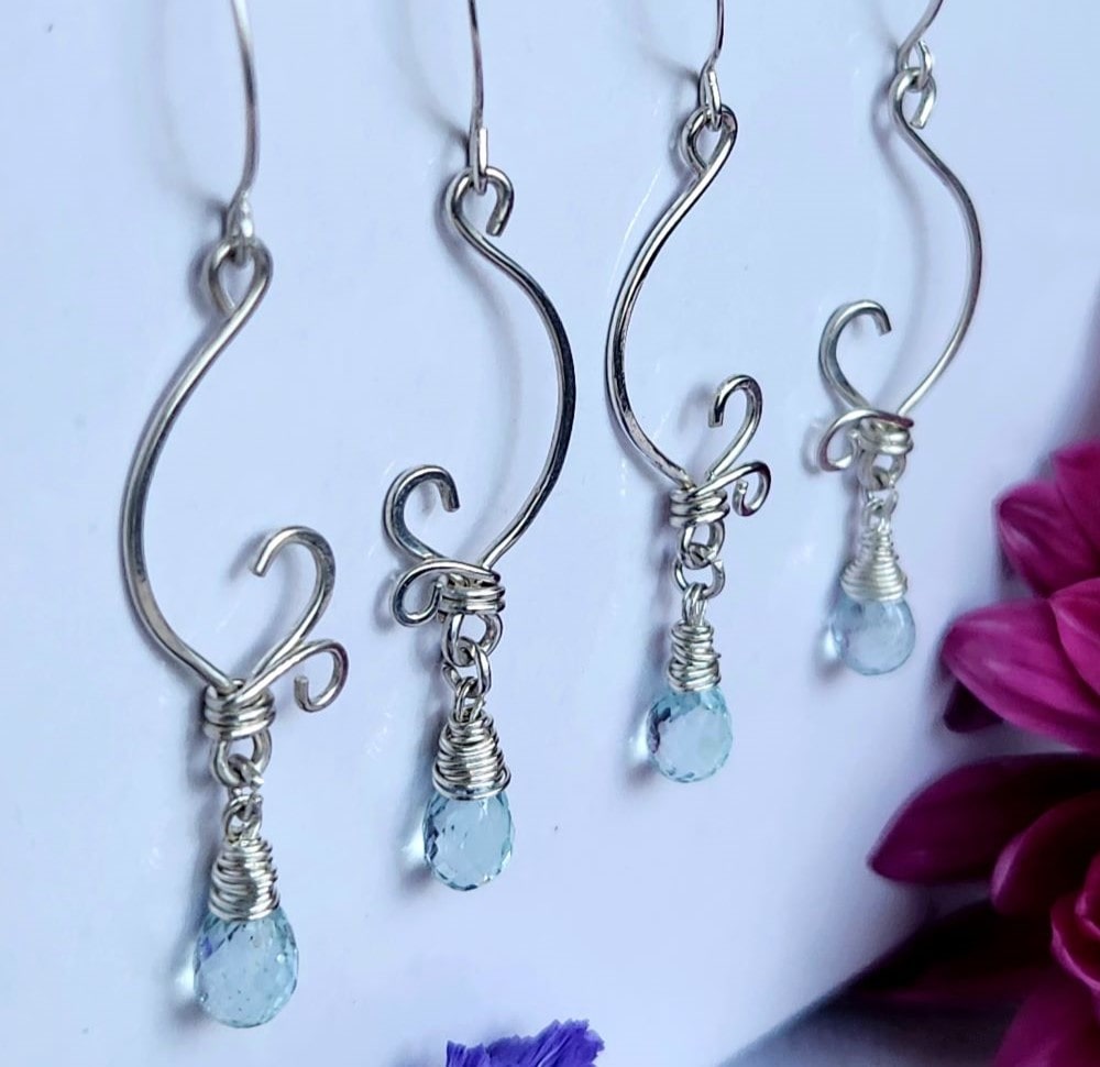 Spring inspired handmade sterling silver aquamarine earrings in a row with spring flowers