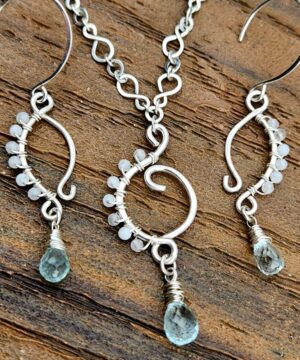 Handmade wire-wrapped moonstone jewelry set on wood