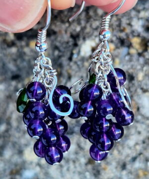 Handmade amethyst sterling silver earrings in front of stone
