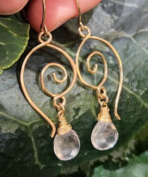 Handmade 14k gold-filled heart-inspired earrings on leaf