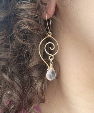 Handmade heart-inspired gold earrings worn