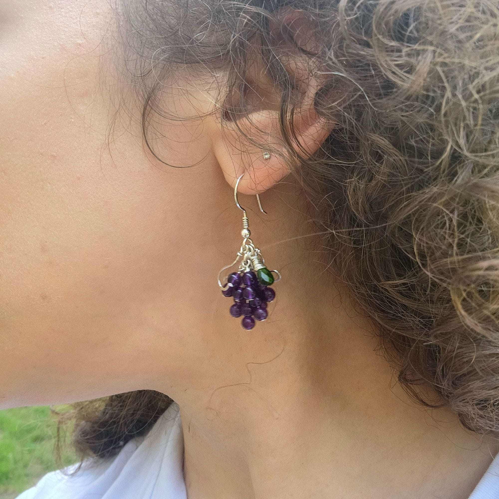 Wearing wire wrapped sterling silver amethyst earrings in natural setting outside